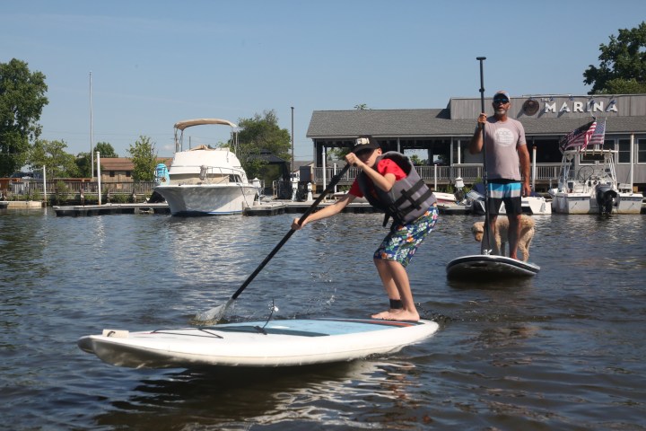 a man riding on the back of a boat in the water