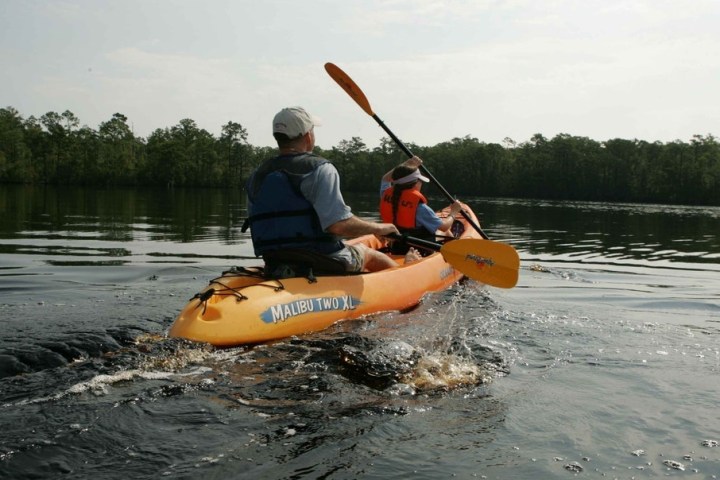 a man riding on the back of a boat in a body of water